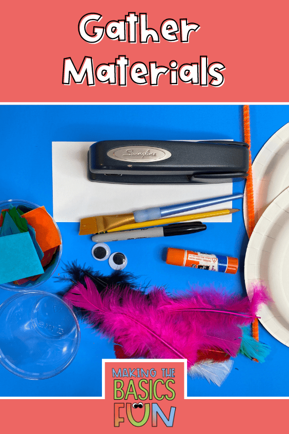 Supplies, stapler, on a white rectangle of paper, wide bristle paint brush, black sharpie and pencil. to the right a pipe cleaner and two paper plates, 2 googly eyes, glue stick, feathers, a cup of water and a cut of bleeding tissue paper squares